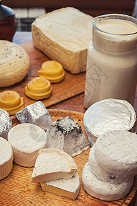 一套不同的奶酪熟食团体木板农民手工乳酪桌子蓝色坚果牛奶图片