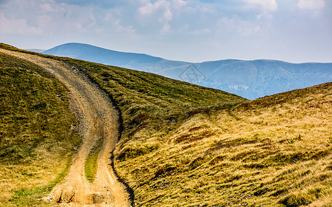 夏季穿过山丘的长路上坡草地踪迹戏剧性小路旅行边缘旅游缠绕山坡图片