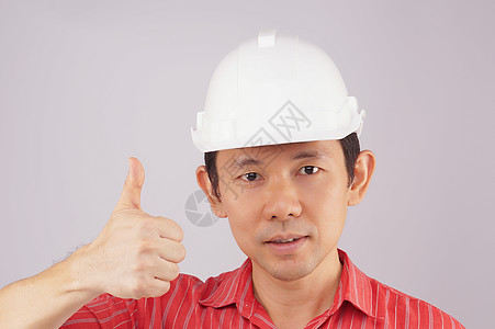 工程师穿红衬衫 白帽子做信号拇指图片