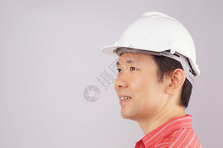快乐的工程师穿红衬衫 戴帽子相望图片