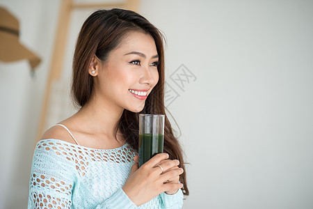 年青的年轻女子 喝绿色新鲜蔬菜汁或食物女孩饮食玻璃女性奶昔排毒营养图片