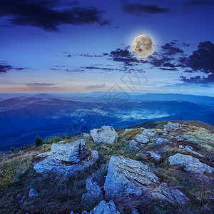 夜间森林在石坡上闪亮的灯光射线月亮山坡旅游风景边缘天空草地场地爬坡图片