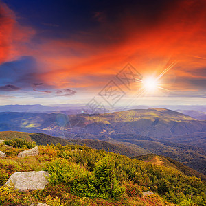 日落时有森林的石山坡上的灯光山坡场地旅游风景天空草地植物石头旅行日落图片