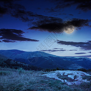 夜间森林在石坡上闪亮的灯光风景边缘旅行山坡石头场地植物戏剧性爬坡草地图片