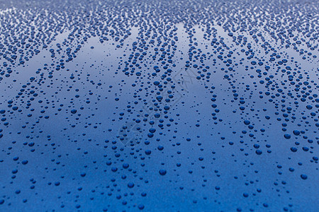 蓝色闪亮光滑表面上的雨滴图片