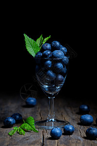 小玻璃杯蓝莓树叶食物宏观玻璃木头浆果荒野桌子甜点食品图片