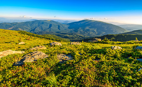 山脊顶上草地上的巨石高度戏剧性旅行绿色环境荒野岩石风景爬坡天空图片