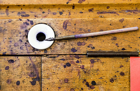 学校木制桌子上的旧的简单老式木用钢笔艺术套圈墨水瓶写作墨水池鹅毛笔手工金属古董回忆图片