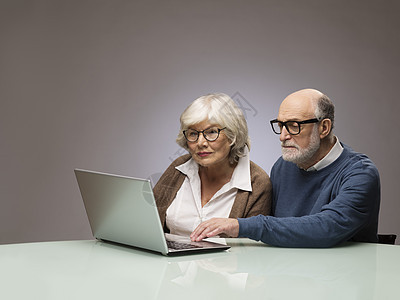 检查膝上型电脑的老年夫妇互联网笔记本男人工作室退休养老金女性桌子丈夫长老图片