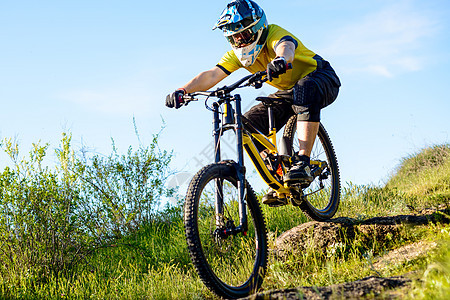 黄色T恤专业赛车员和黑发骑马骑着极端运动概念速度山地车头盔自行车骑士运动员竞赛蓝色成人男性图片