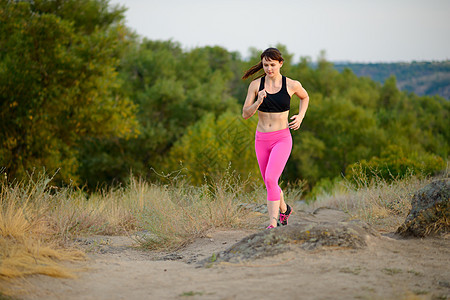 年轻女子在山道上奔跑 活跃的生活方式概念 笑声保健训练卫生踪迹慢跑者公园耐力女性慢跑女士图片