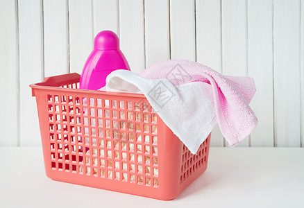 洗衣篮中的特里毛巾和洗涤剂浴室柔软剂瓶子衣篮红色家务打扫织物液体粉色图片