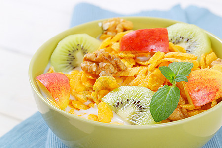 带奶粉和新鲜果实的玉米薄片谷物早餐黄色奇异果绿色食物水果牛奶核桃图片
