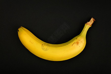 一只熟的黄黄色香蕉 在黑色上被隔绝图片