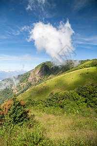 蓝色天空和云彩的绿色山脉垂直景象图片