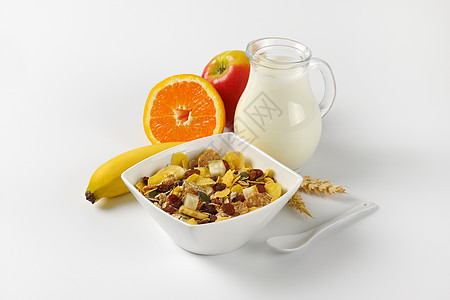 早餐谷物 牛奶和新鲜水果营养水壶勺子橙子香蕉葡萄干燕麦食物静物背景图片
