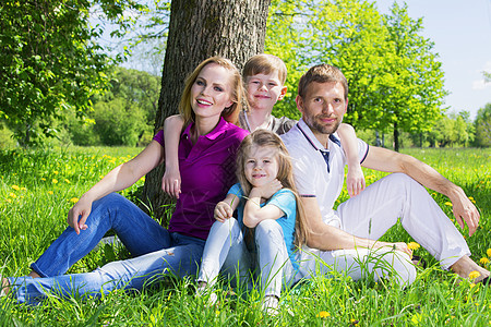 夏季公园的草地上家庭孩子们女儿男性父亲闲暇女孩女性女士孩子幸福图片