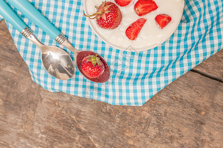 在一杯酸奶和新鲜草莓 蓝汤匙毛巾上盘子厨房覆盆子桌子鞭打玻璃浆果早餐甜点美食图片