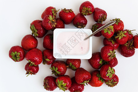 装有酸奶和白上一堆新鲜草莓的容器奶制品甜点奶油食物小吃饮食盒子营养塑料杯子图片