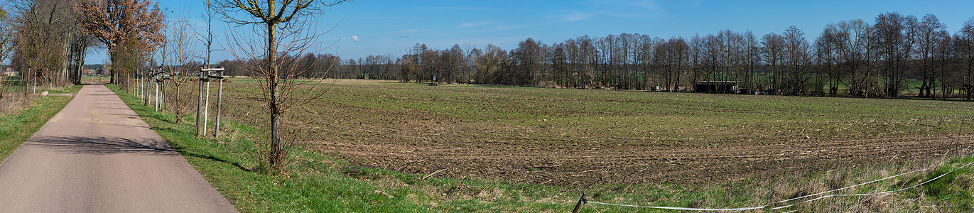 两个村庄之间的乡村公路天空牧场缠绕村道农田草地气候条纹农业植物背景图片