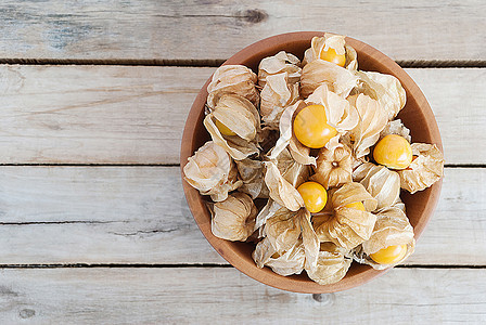 Cape 鹅莓Physalis 木质碗中的木板 愈合营养素季节醋栗浆果小吃橙子果味水果金子植物图片