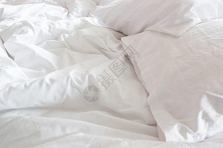床上白色枕头和有皱纹的乱毯子的白枕头卧室情人软垫羽绒酒店房间家具棉被家庭被子图片