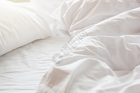 醒来后卧室的皱纹乱成一团的毯子和白枕头情人酒店亚麻房间软垫家具床垫风格被子奢华图片