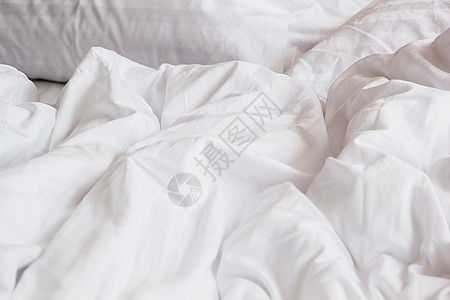 羽绒被子床上白色枕头和有皱纹的乱毯子的白枕头羽绒床垫房间酒店床单棉被家具被子家庭服务背景