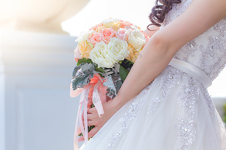 新娘拿着一束鲜花来参加婚礼图片
