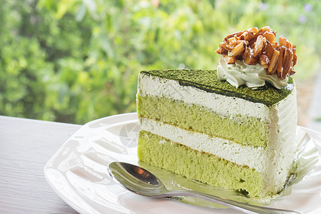 咖啡店里的绿色茶蛋糕和自然的背黑锅黄色美食抹茶蛋糕杯子饮食白色甜点文化奶油图片