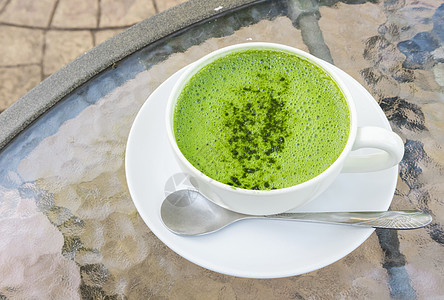 在玻璃桌背面加杯火辣拿铁或绿茶奶油塑料茶点食物稻草牛奶桌子营养饮料杯子背景图片