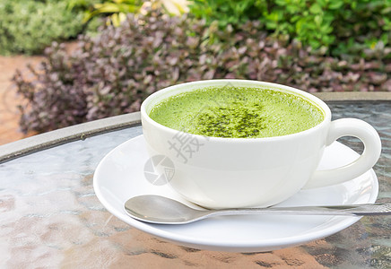 在杯子上用n 特写一杯火辣拿铁或绿茶桌子饮料抹茶食谱稻草牛奶咖啡店食物营养玻璃背景图片