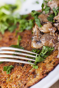 配蘑菇酱的土豆煎饼土豆木头奶油香菜食物小吃盘子午餐烹饪油炸图片