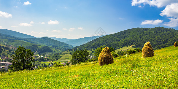 村附近山坡上的干草堆全景乡村国家风景农业场地季节干草爬坡天空图片