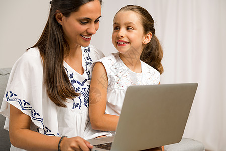 工作的女人母亲和女儿在家里拉丁互联网老师教育学生成人孩子家庭作业家庭父母背景