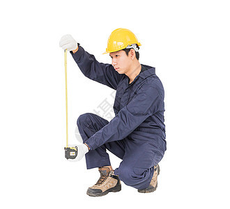 年轻工人在单人区 用白色隔离的胶带措施磁带工人劳动者石匠男人头盔厘米工业测量统治者图片
