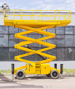 对工业建筑的剪刀轮式升降机背景图片