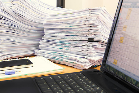 电脑笔记本和文件在办公桌上堆叠 等待知识合同数据桌子团体文书工作收据库存职场报告高清图片素材