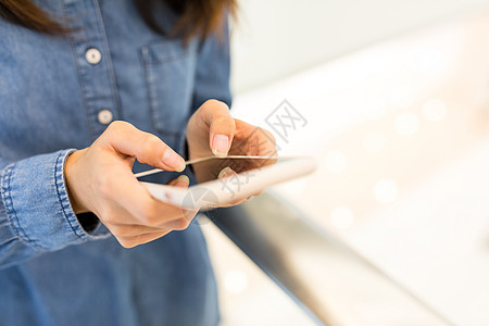 女人触摸智能手机身体游戏阅读蓝色冲浪背景女性电话牛仔裤女孩图片