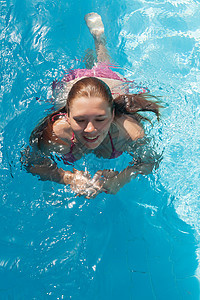 眼闭眼笑着的年轻女子 在泳池游泳图片