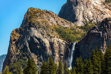 Yosemite的瀑布在夏日顶峰地标地质学山脉天空公园悬崖树木环境船长图片