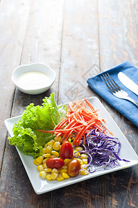 木制桌上的新鲜健康沙拉敷料木头紫色午餐橙子杯子蔬菜食物营养叶子图片