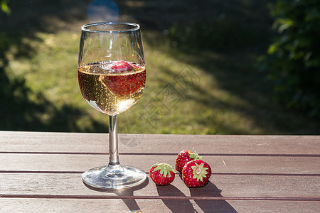 配有闪亮葡萄酒和草莓的闪光玻璃图片
