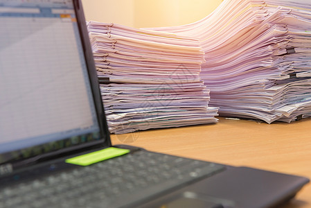 电脑笔记本和文件在办公桌上堆叠 等待合同团体会计报告库存商业桌子组织文档收据知识高清图片素材