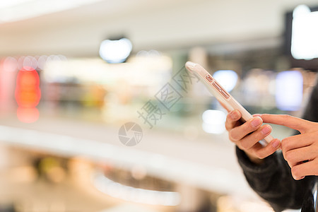 女性使用移动电话的情况女孩玻璃中心阅读购物中心细胞购物天花板建筑学商业图片