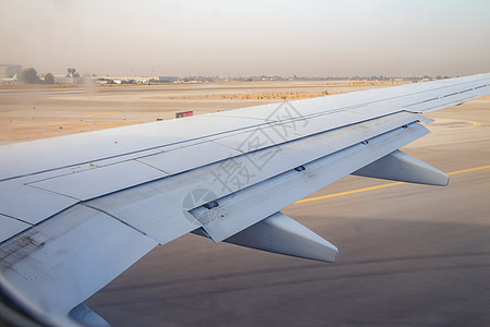 日出时班古里昂机场跑道上的飞机机翼翅膀飞行太阳机场空气航空运输航班窗户喷射图片