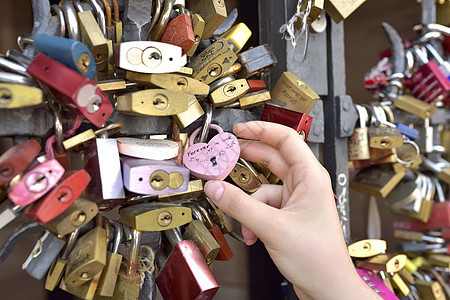 女孩手上的爱情锁巴塞尔瑞士2017 年 7 月 21 日挂锁艺术类情人夫妻栅栏栏杆钥匙旅行地标友谊图片