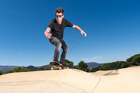 跳泵轨道公园上的滑板机跳跃滑板青年男生男性滑冰溜冰者文化日出运动图片
