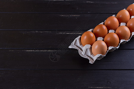 黑木木背景纸板彩蛋盒棕色营养黑色早餐农场椭圆形纸盒白色蛋壳食物图片