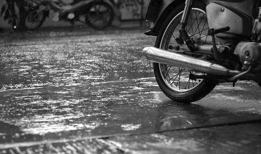 摩托车和雨滴特写车辆下雨波纹雨量反射池塘骑术天气人行道水坑图片